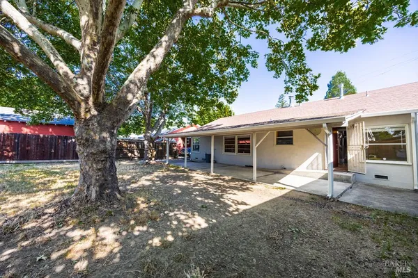 a view of a house with backyard and a tree