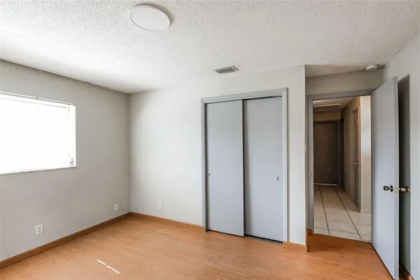 an empty room with windows and closet