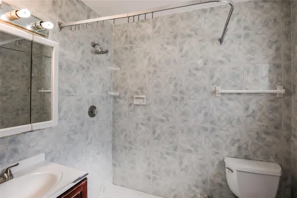 a bathroom with a shower toilet and sink