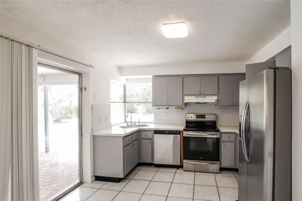 a kitchen with a sink a refrigerator and cabinets