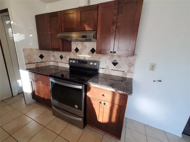 a stove top oven sitting inside of a kitchen