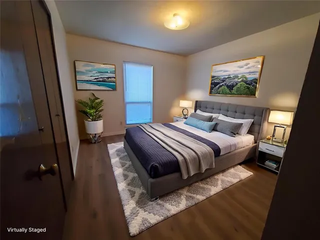 a bedroom with a bed and a painting on the wall