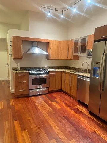 a kitchen with stainless steel appliances granite countertop a stove a sink and a refrigerator
