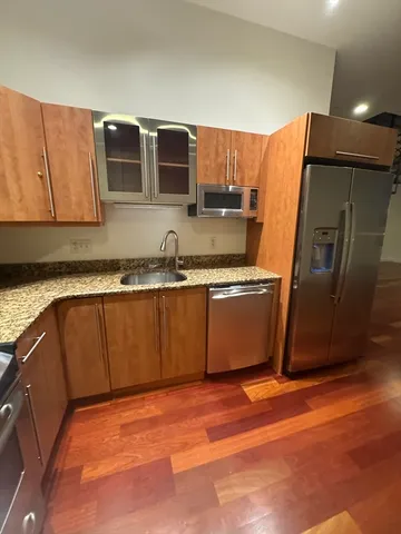 a kitchen with stainless steel appliances granite countertop a sink a stove top oven and granite counter tops