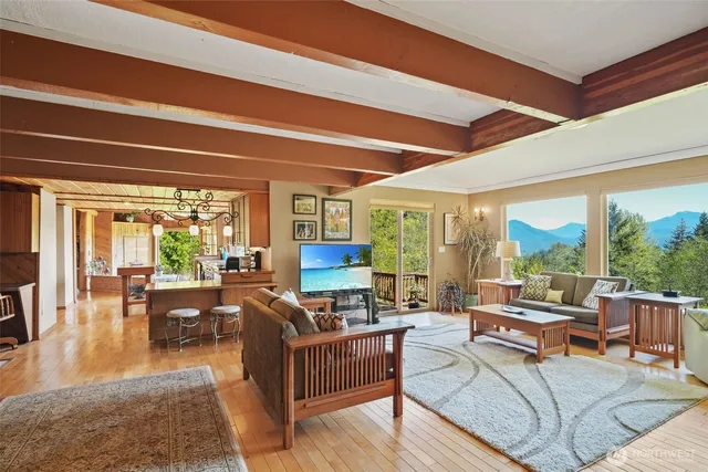 a living room with furniture a large window and wooden floor