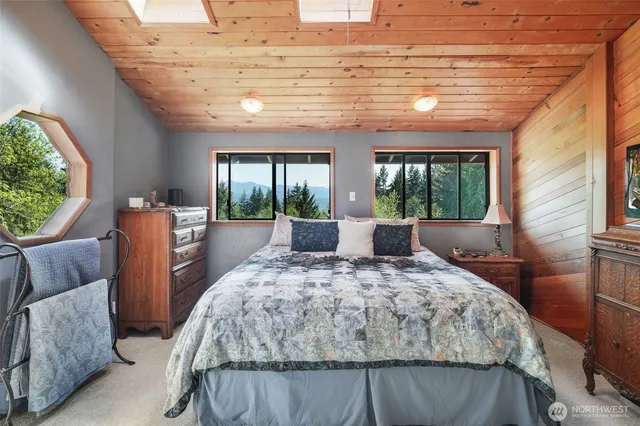 a bedroom with a large bed and windows