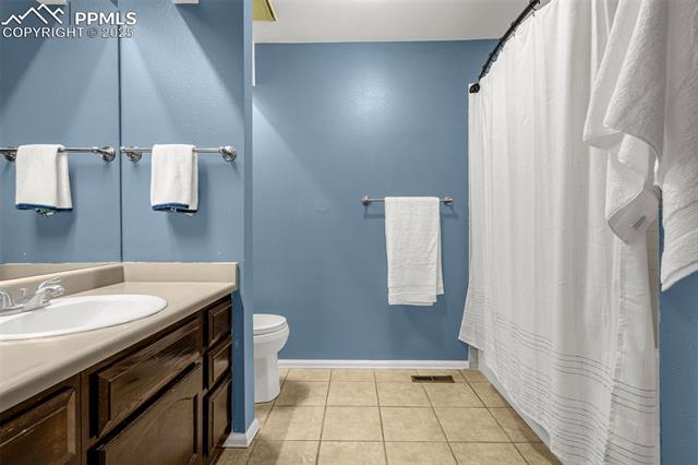 4990 Castledown Road Colorado Springs, CO 80917 - Photo 17 of 37 Bathroom with tile patterned floors, visible vents, toilet, vanity, and baseboards
