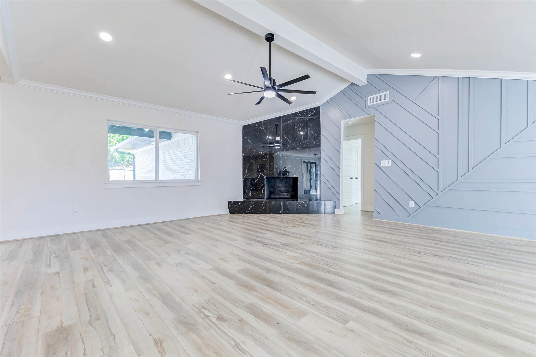 6106 Rutherglenn Drive Houston, TX 77096 - Photo 11 of 43 an empty room with wooden floor ceiling fan and windows