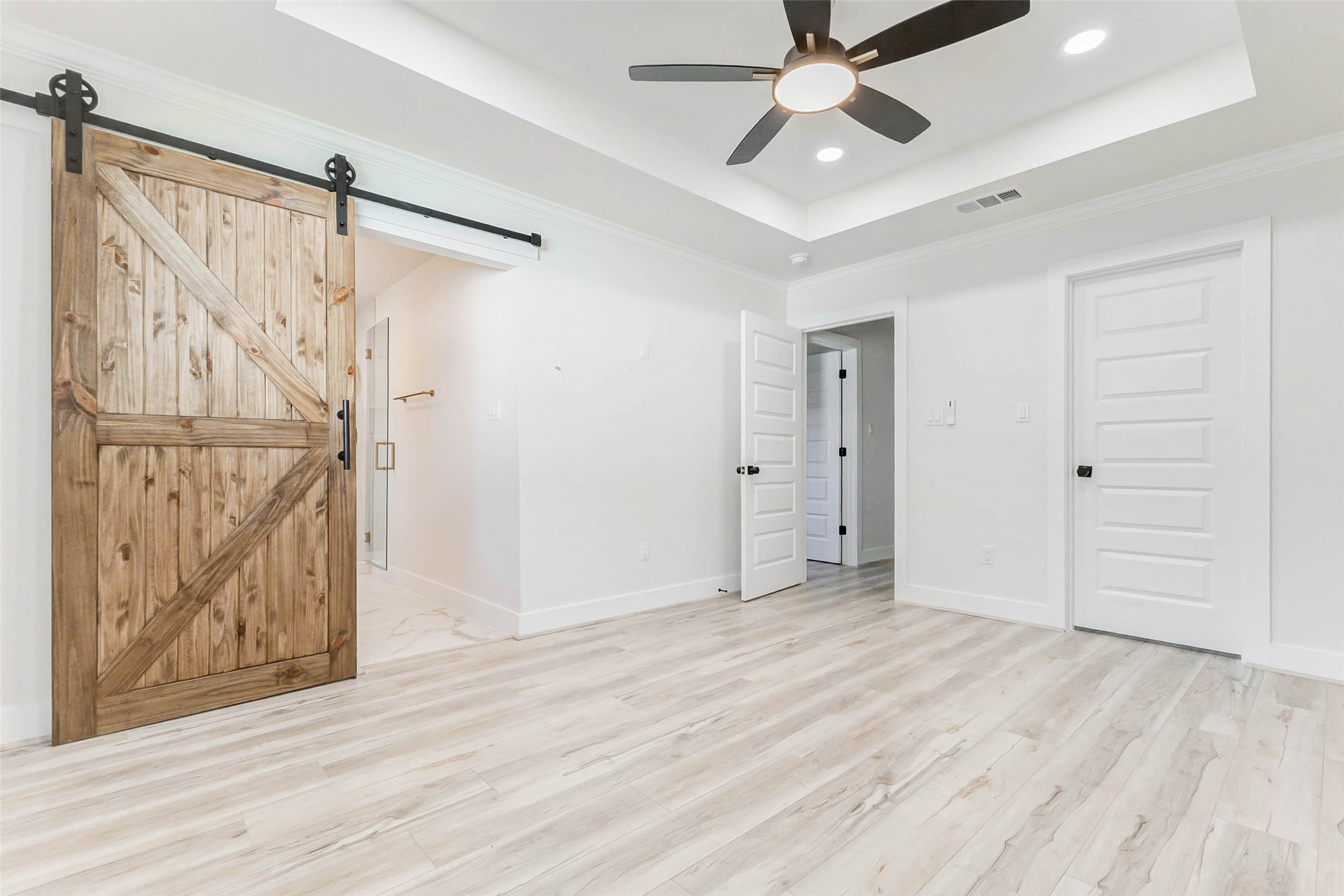 6106 Rutherglenn Drive Houston, TX 77096 - Photo 24 of 43 a view of an empty room with wooden floor and a ceiling fan