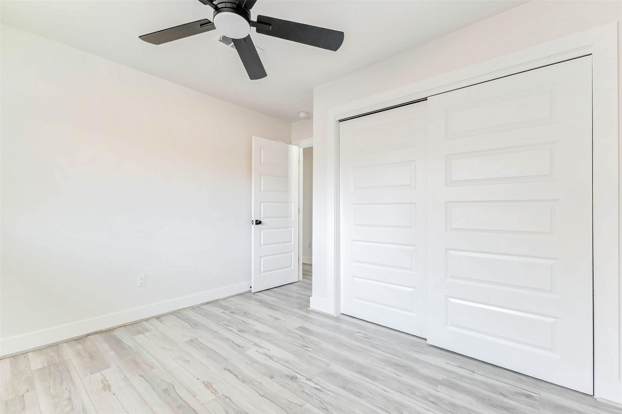 6106 Rutherglenn Drive Houston, TX 77096 - Photo 31 of 43 an empty room with a ceiling fan and wooden floor