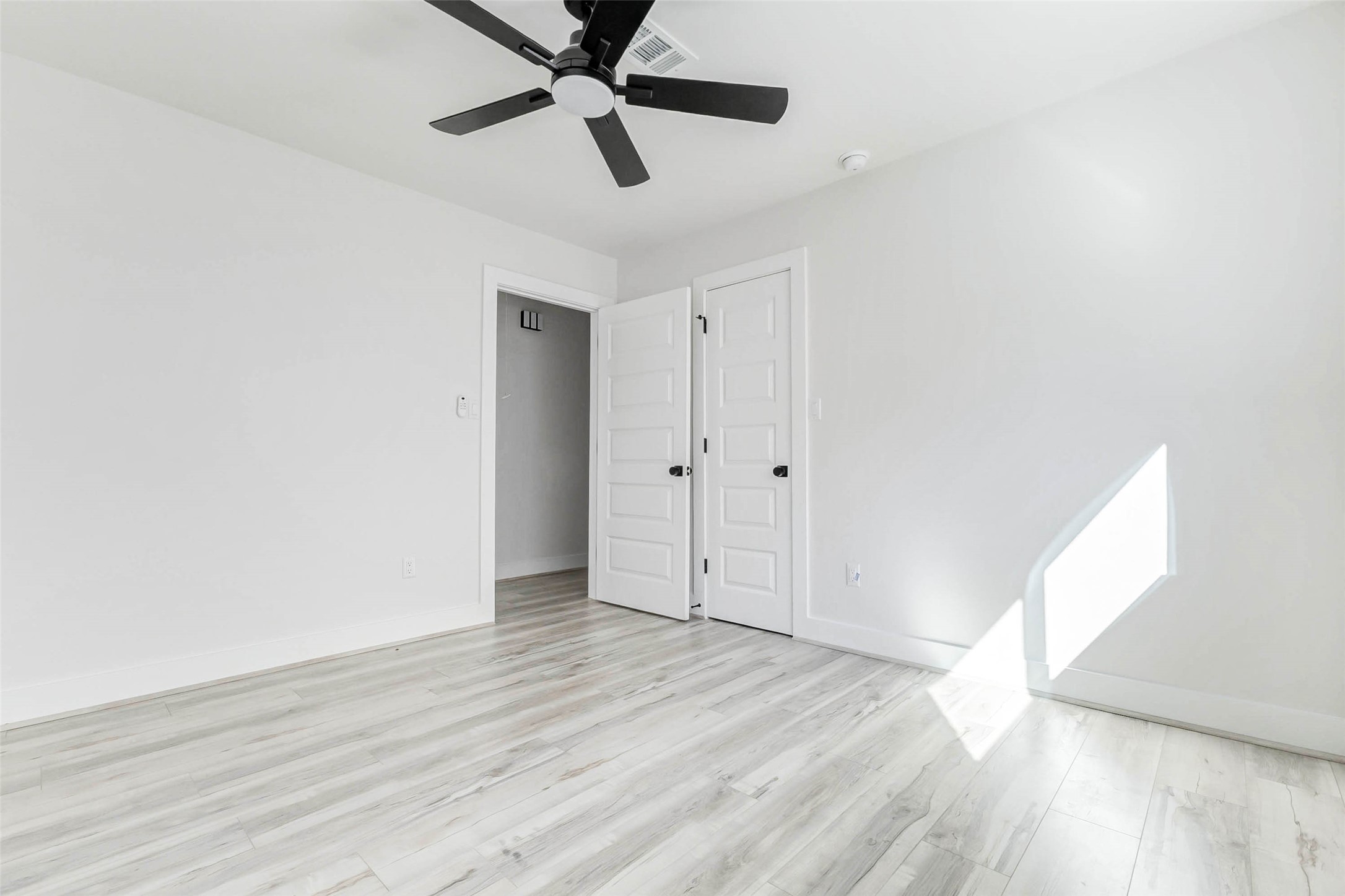 6106 Rutherglenn Drive Houston, TX 77096 - Photo 33 of 43 an empty room with wooden floor a ceiling fan and windows