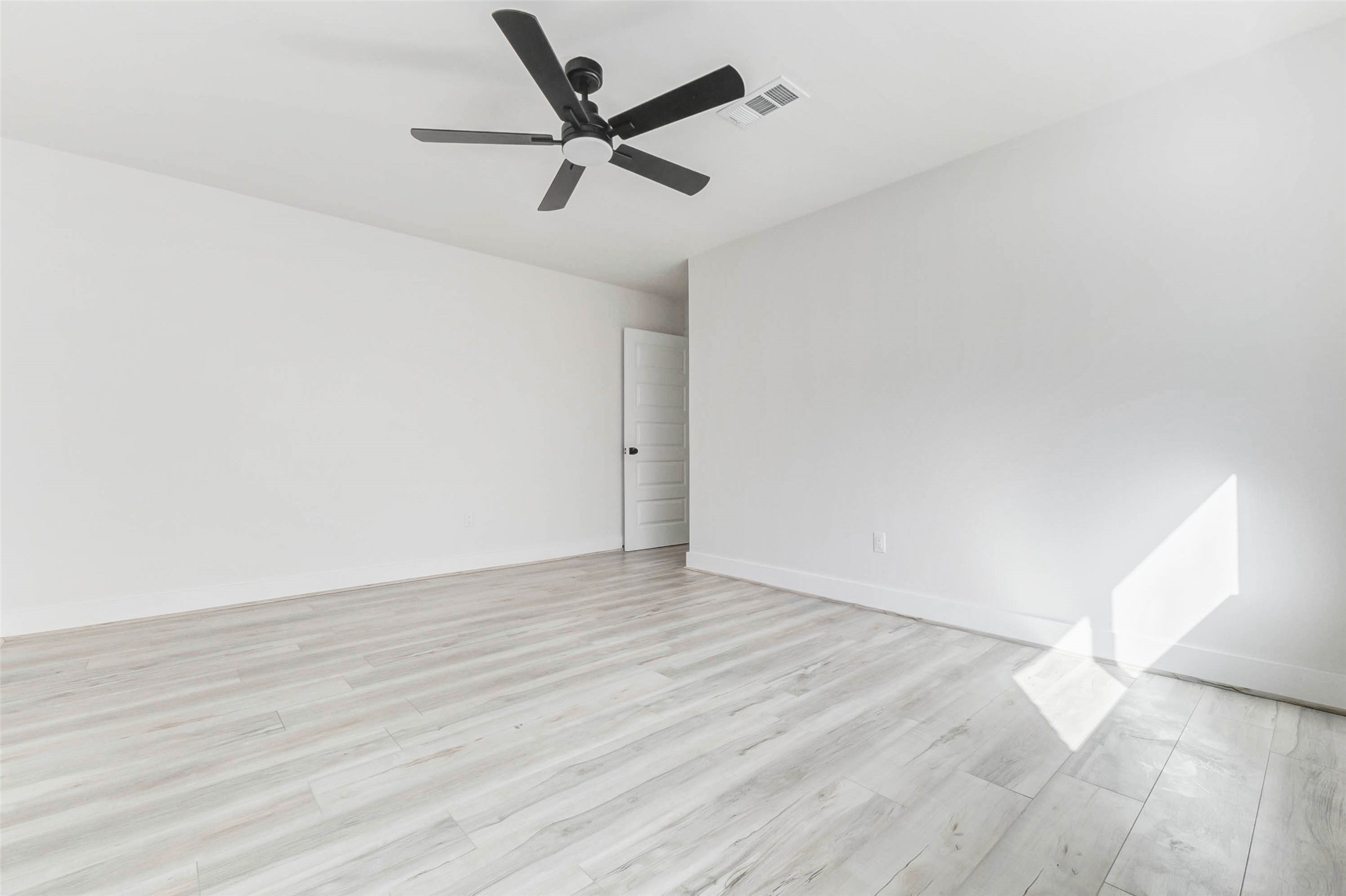 6106 Rutherglenn Drive Houston, TX 77096 - Photo 35 of 43 an empty room with wooden floor and a ceiling fan