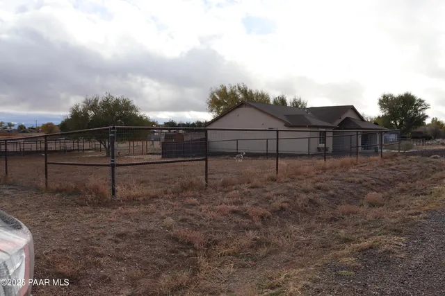 a view of a yard with wooden fence