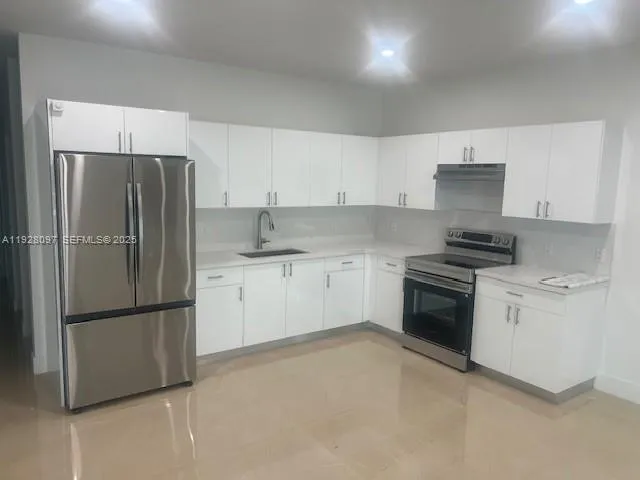 a kitchen with granite countertop a refrigerator stove and microwave
