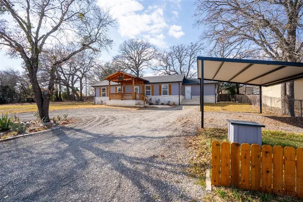 a front view of house with yard and trees around