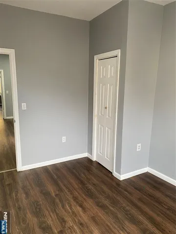 an empty room with wooden floor and closet