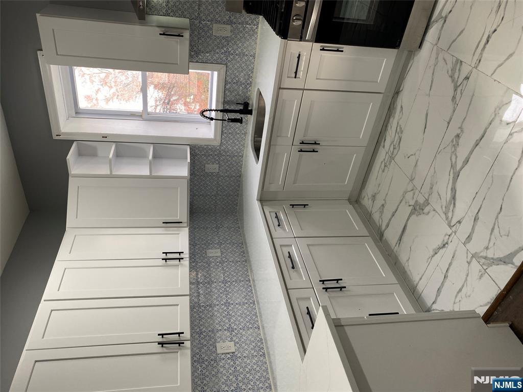 540 South 20th Street, Unit 2 Newark, NJ 07103 - Photo 2 of 13 a kitchen with white cabinets appliances a sink and a window