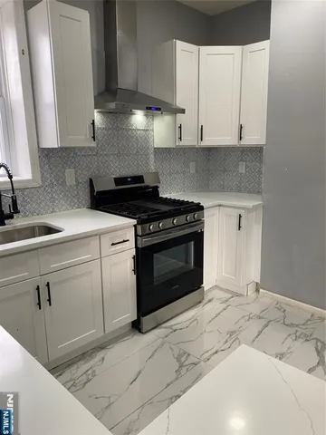 a kitchen with a stove top oven and cabinets