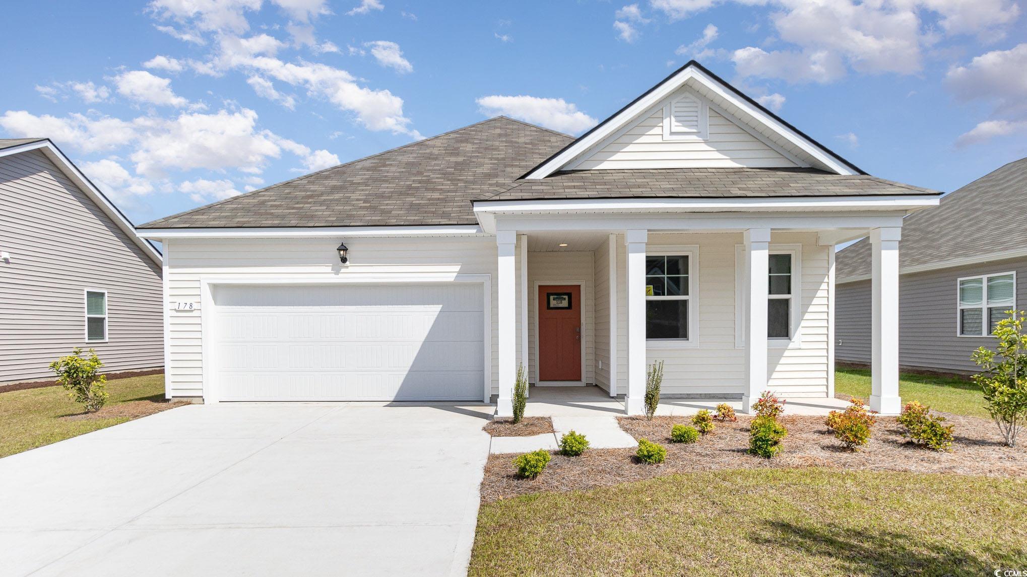 View of front of house featuring a shingled roof, a porch, concrete driveway, a front lawn, and a garage