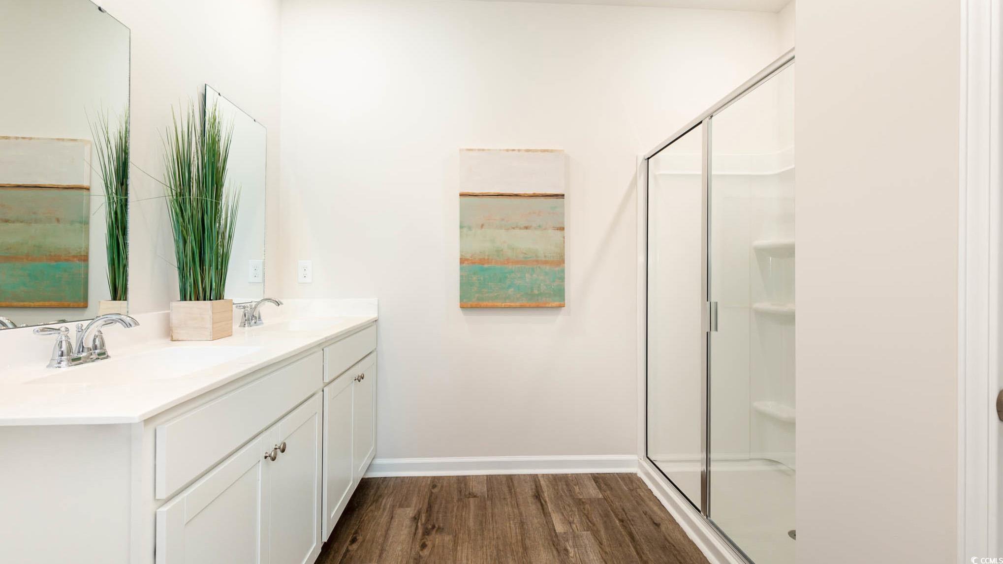 2083 Locust Ridge Drive Shallotte, NC 28470 - Photo 16 of 22 Bathroom with double vanity, a shower stall, and dark wood-type flooring