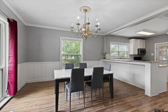 a view of a dining room with furniture a chandelier and wooden floor