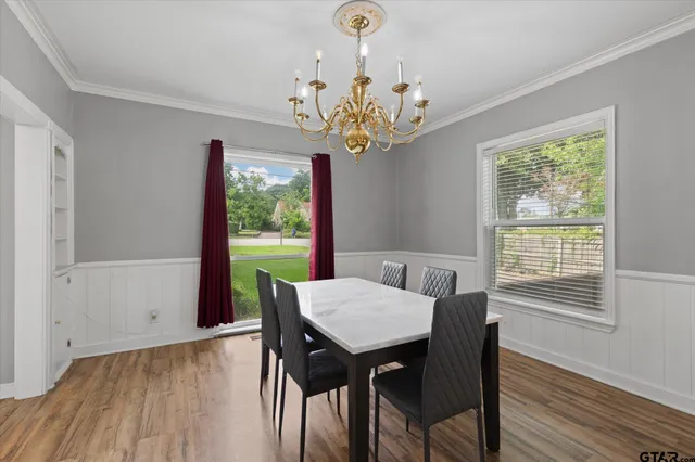 a view of a dining room with furniture a chandelier and wooden floor