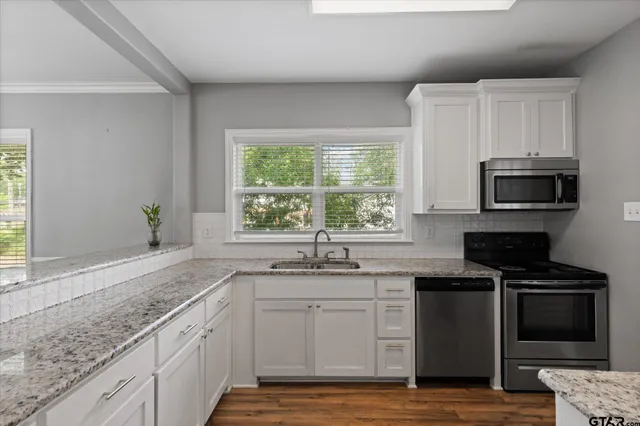 a kitchen with granite countertop a sink and a stove top oven