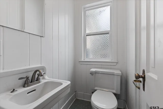 a bathroom with a sink a toilet and a mirror