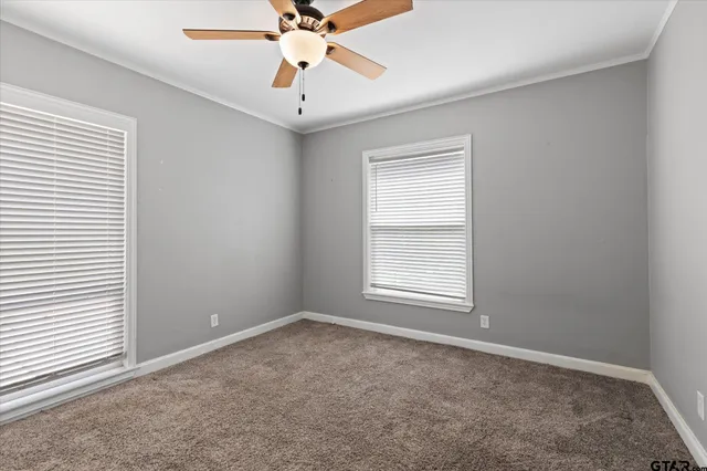 an empty room with a window and a fan