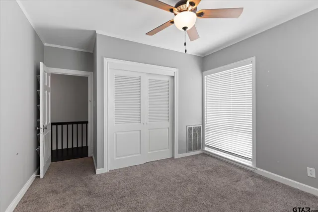 a view of a room with a ceiling fan and a window