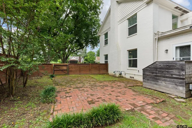 a view of a house with backyard and trees