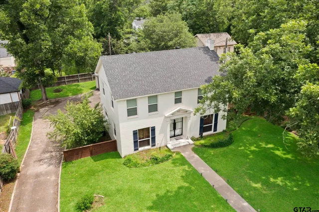 a aerial view of a house with a yard table and chairs