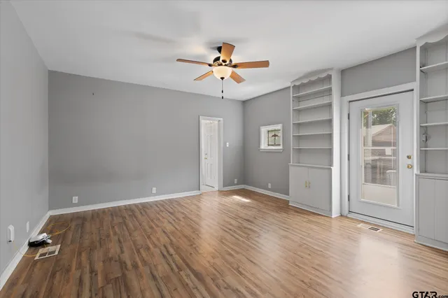 wooden floor in an empty room with a window