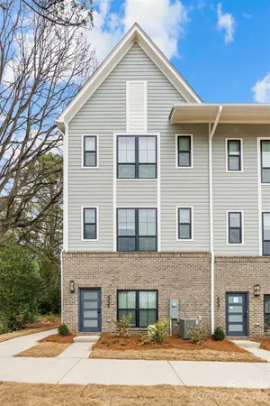 a open kitchen with stainless steel appliances granite countertop a refrigerator a sink dishwasher a stove and white cabinets with wooden floor