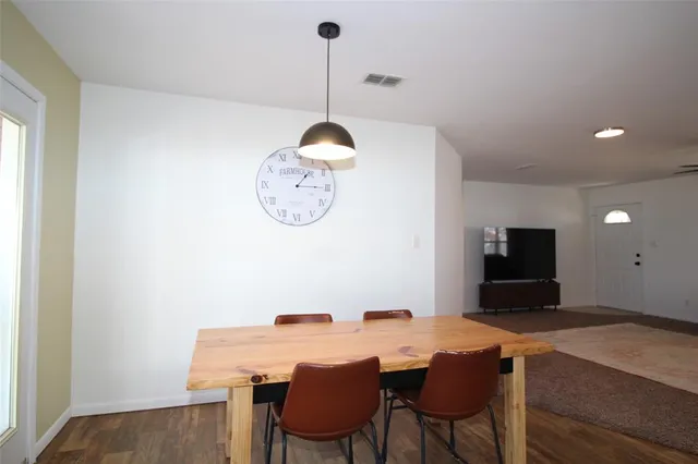 a view of a dining room with a table and chairs