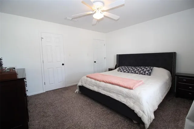 a bedroom with a bed and a ceiling fan