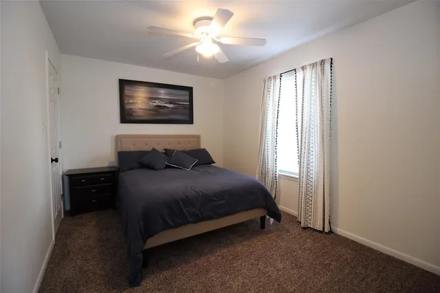 a bedroom with a bed and a ceiling fan