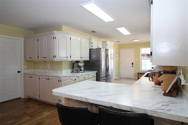 a kitchen with stainless steel appliances granite countertop a sink refrigerator and cabinets