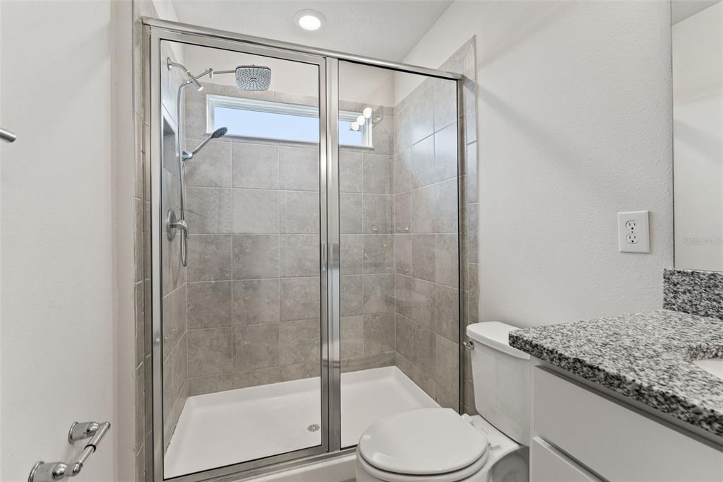 31329 Amberview Bend Wesley Chapel, FL 33545 - Photo 20 of 57 a bathroom with a granite countertop bathtub shower and toilet