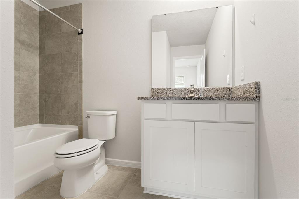 31329 Amberview Bend Wesley Chapel, FL 33545 - Photo 25 of 57 a bathroom with a granite countertop toilet sink and mirror