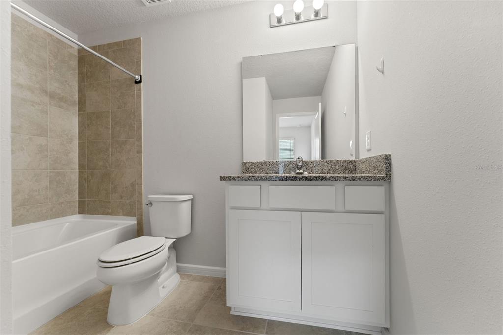 31329 Amberview Bend Wesley Chapel, FL 33545 - Photo 26 of 57 a bathroom with a granite countertop sink toilet and shower