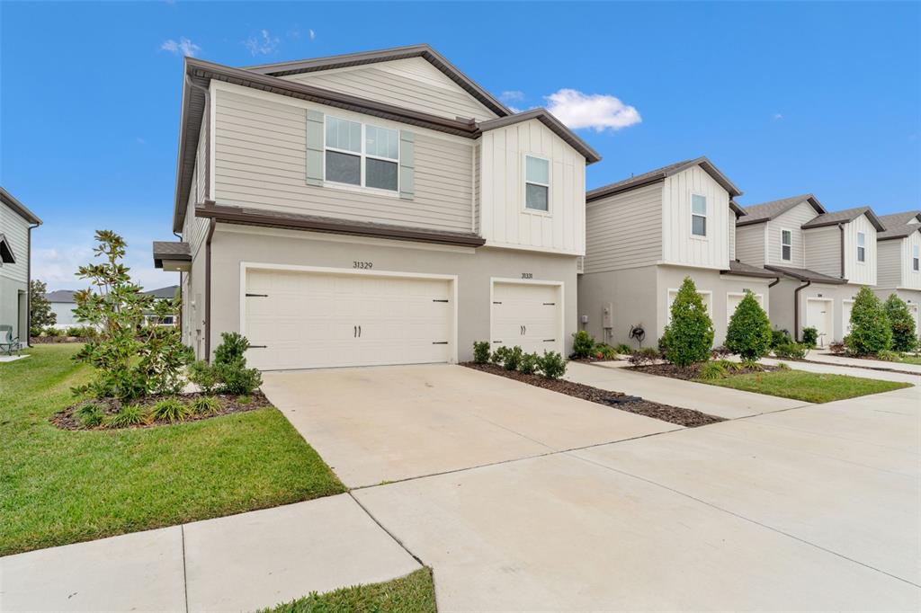 31329 Amberview Bend Wesley Chapel, FL 33545 - Photo 4 of 57 a front view of a house with a yard and garage