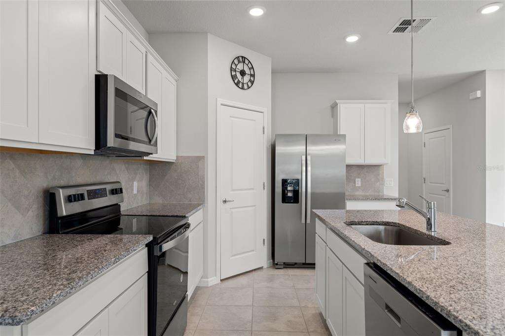 31329 Amberview Bend Wesley Chapel, FL 33545 - Photo 8 of 57 a kitchen with stainless steel appliances granite countertop a sink a stove and a refrigerator