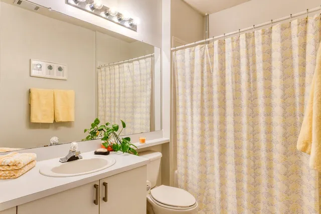 a bathroom with a sink a toilet and a window