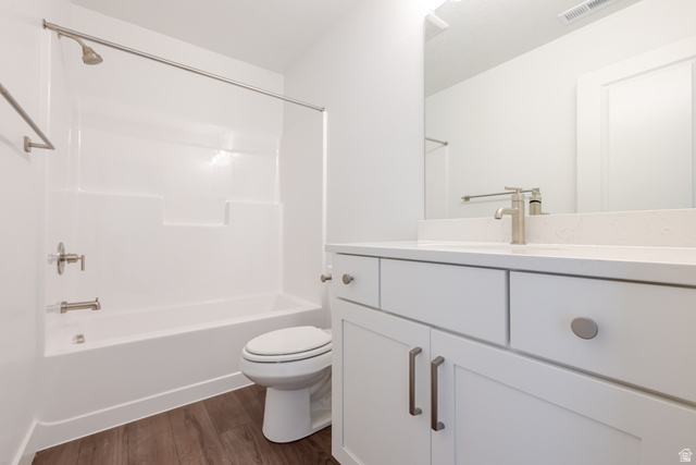 4816 Heartwood Road, Unit 423 Mapleton, UT 84664 - Photo 16 of 21 Bathroom with vanity, dark wood finished floors, and shower combination