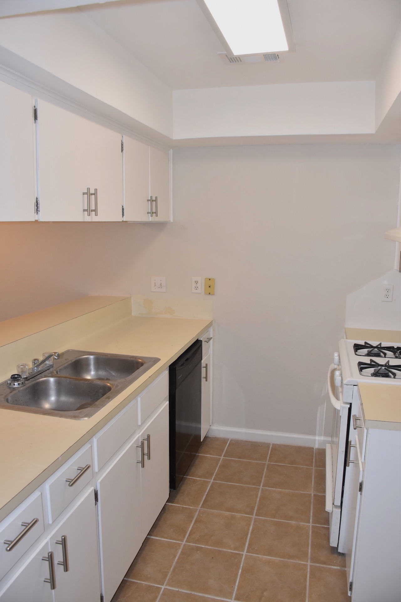1810 Rawhide Loop Round Rock, TX 78681 - Photo 14 of 29 Kitchen featuring light-colored cabinetry, a dual basin stainless steel sink, a black dishwasher, and a white gas range with a matching countertop