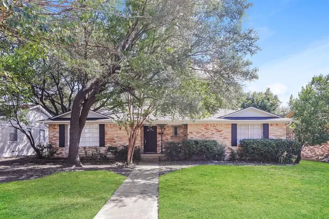 a front view of a house with a garden and yard