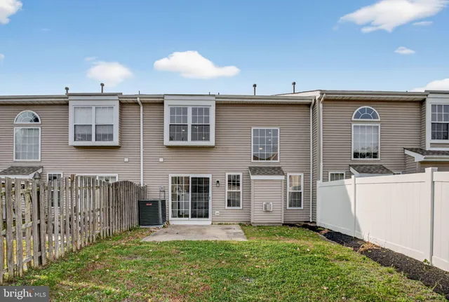 a view of a house with backyard and wooden fence