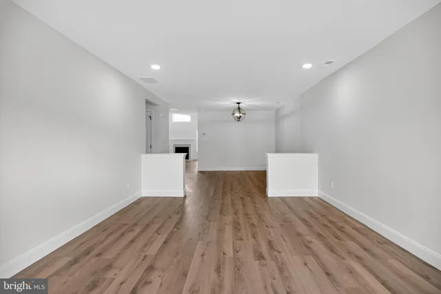 a view of a room with wooden floor and white walls