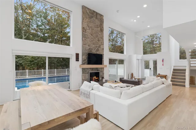 a living room with fireplace furniture and a large window